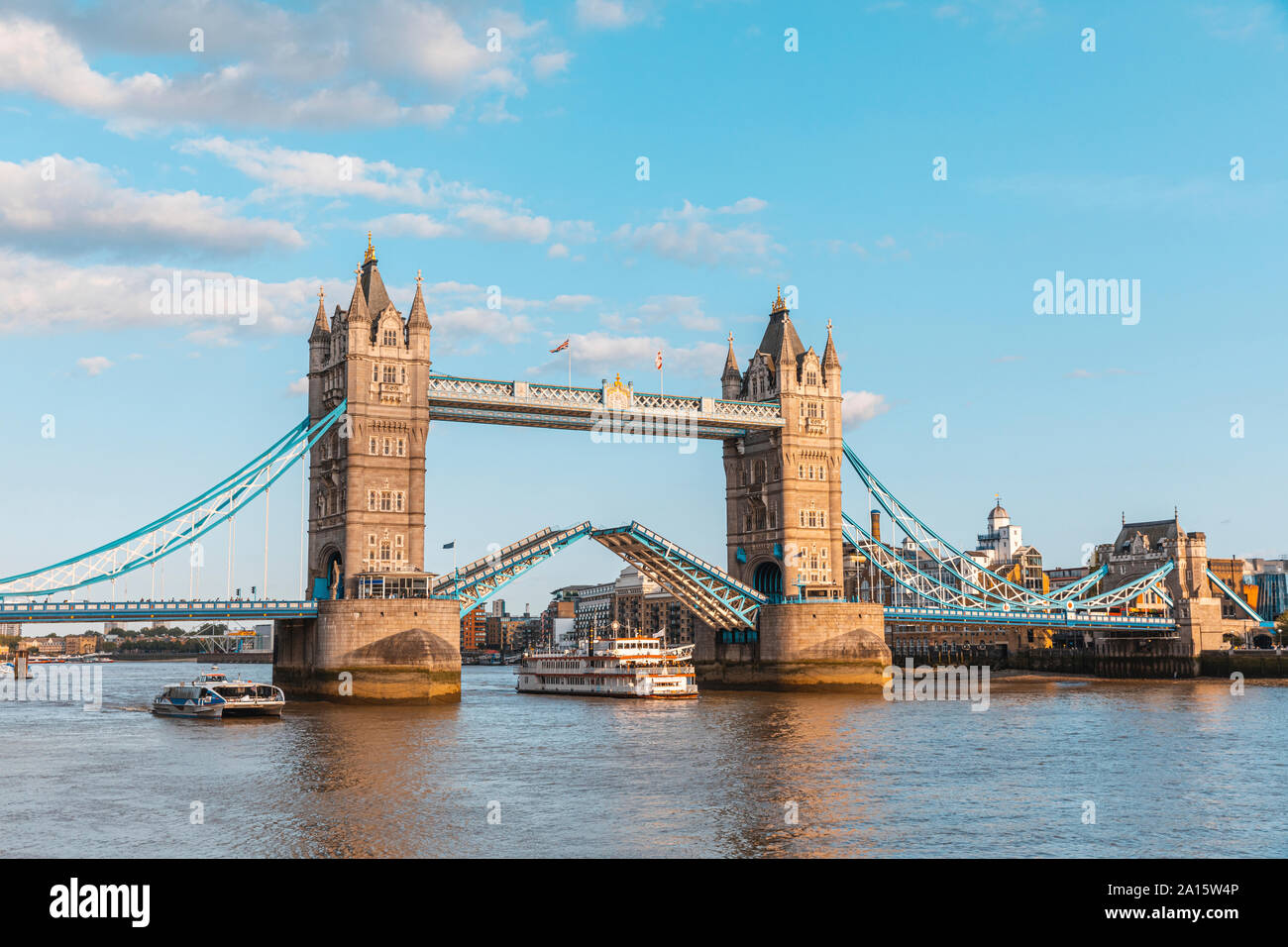 Paddle steamer boat moving under lifted tower bridge hires stock