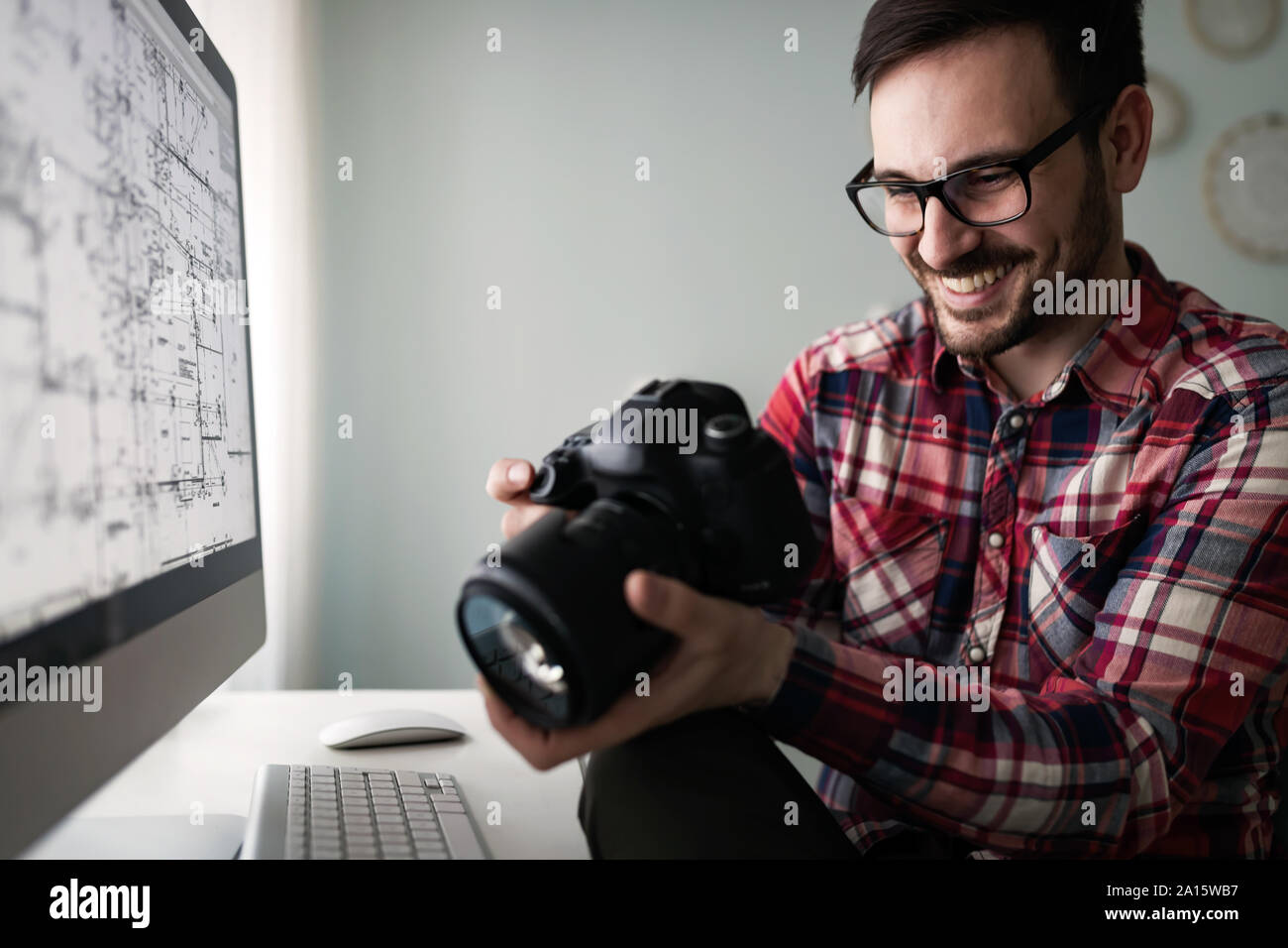 Young handsome designer working on project on computer Stock Photo