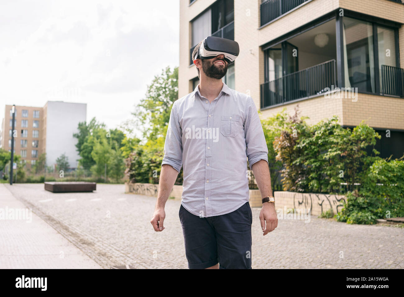 Man wearing Virtual Reality Glasses outdoors Stock Photo