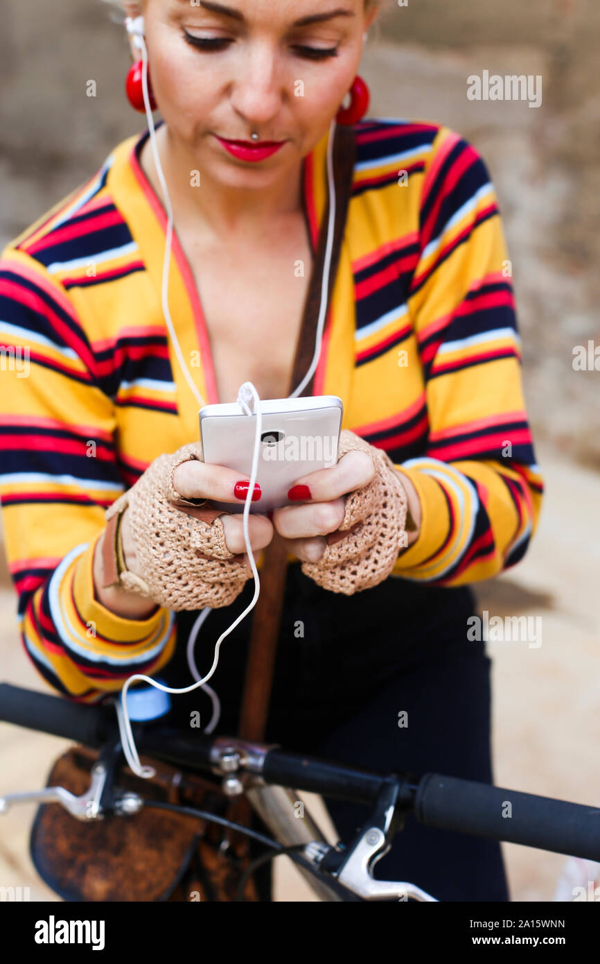 Mature woman with with bicycle text messaging Stock Photo
