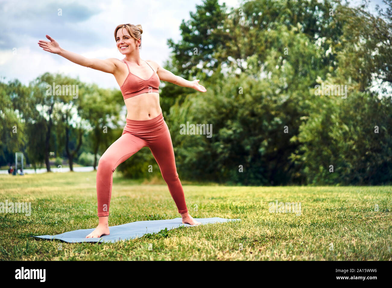 Woman practicing yoga in park Stock Photo