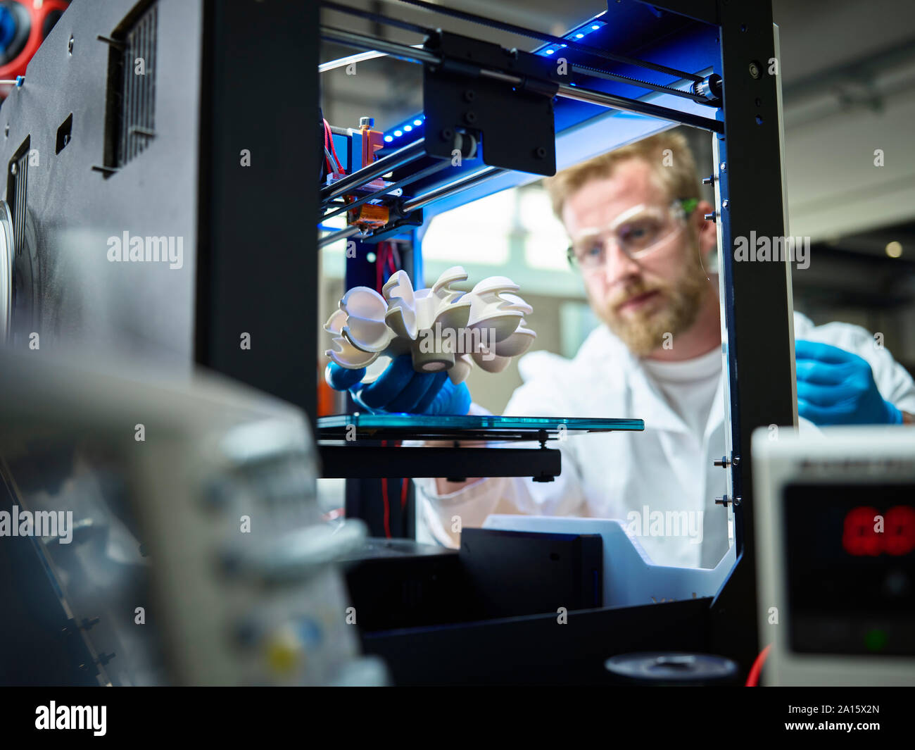 Technician with turbine wheel being printed in 3d printer Stock Photo