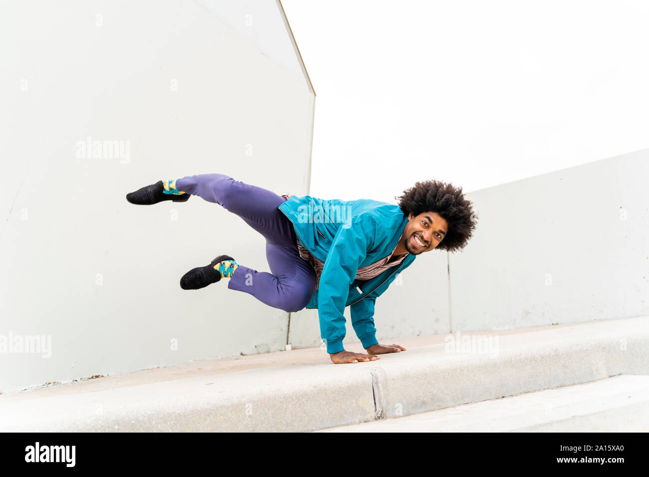 Young hipster man dancing, white wall in the background Stock Photo