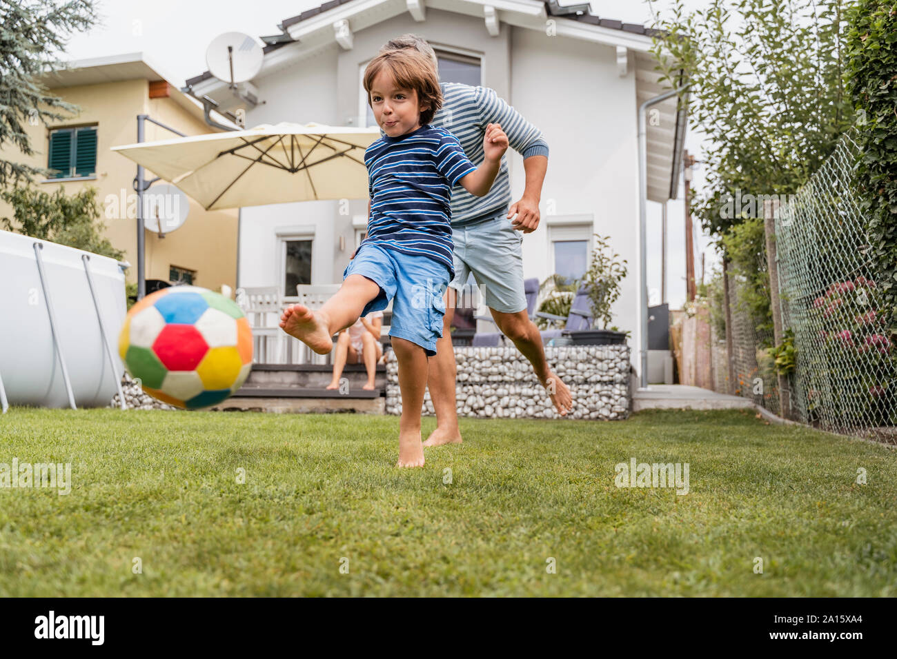 Father and son playing football in garden Stock Photo