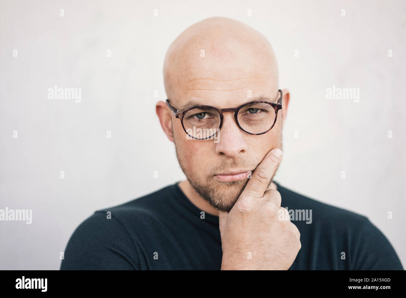 Portrait of starring bald man wearing glasses Stock Photo