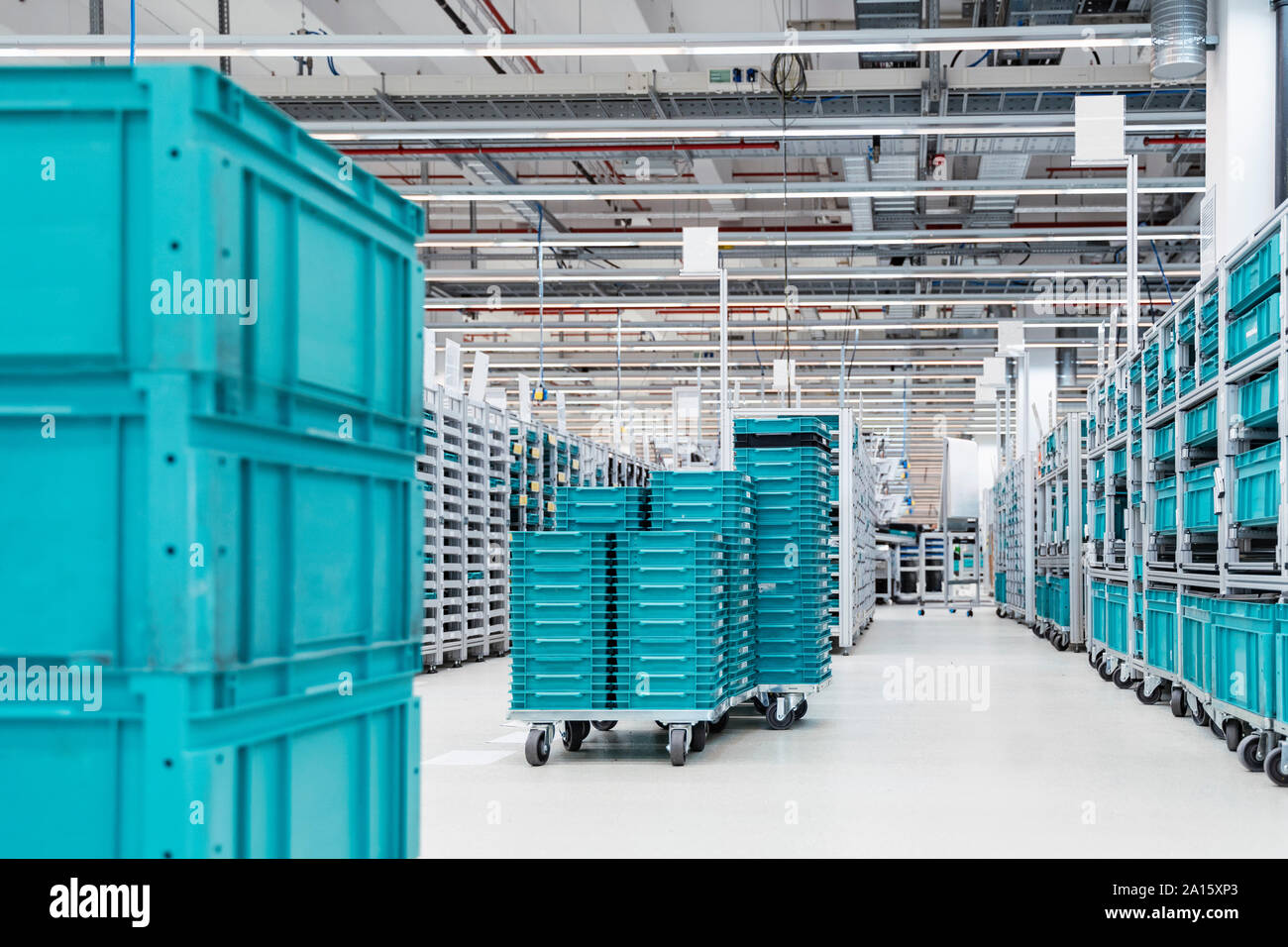 Turquoise colored containers inside modern factory warehouse, Stuttgart, Germany Stock Photo