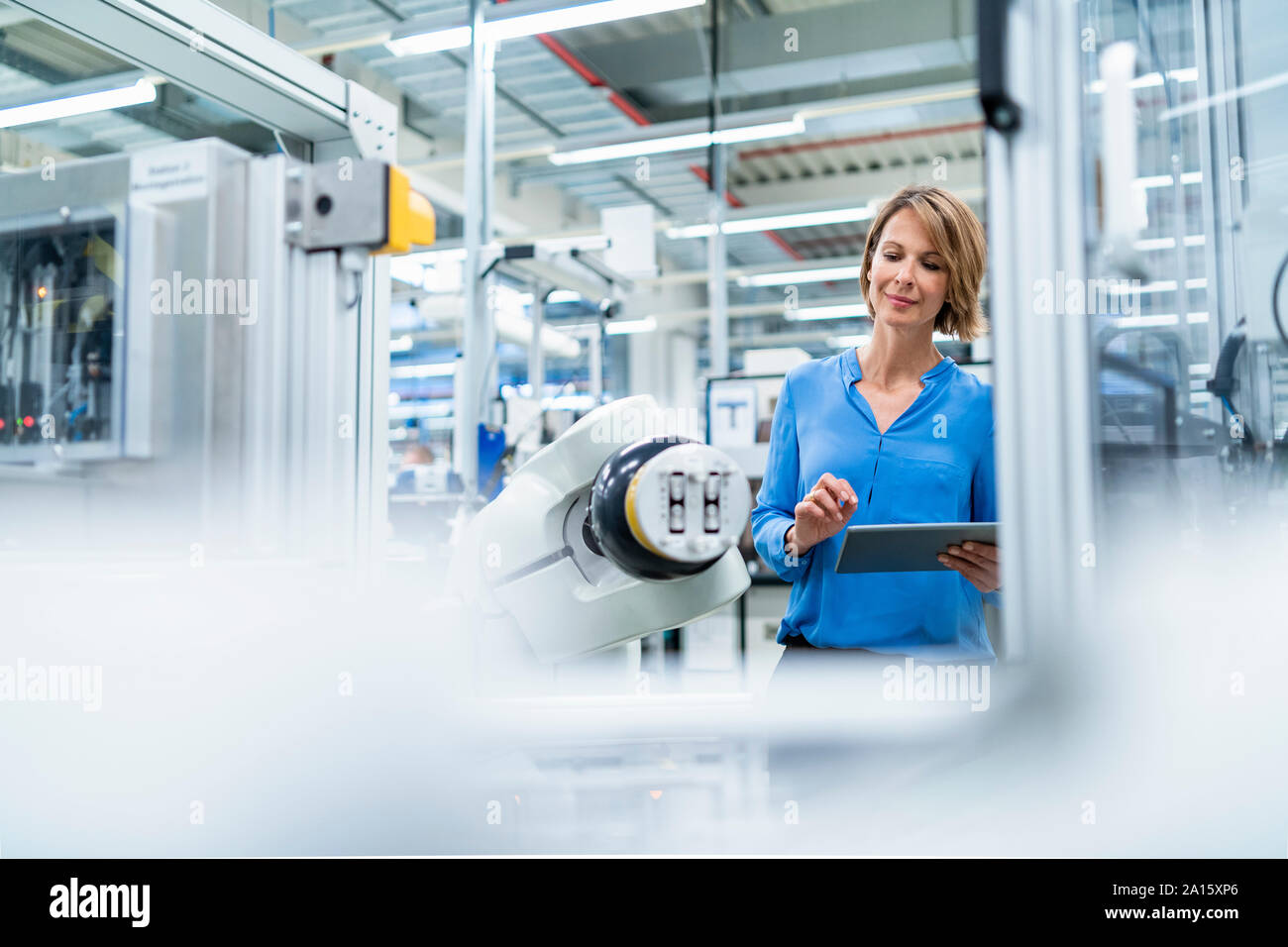 Businesswoman with tablet at assembly robot in a factory Stock Photo