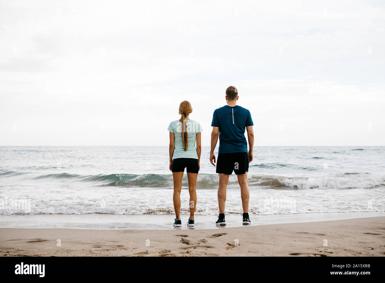 Young couple standing side by side on the beach Stock Photo