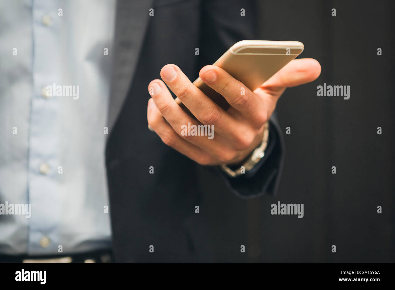 Hand of businessman holding mobile phone, close-up Stock Photo