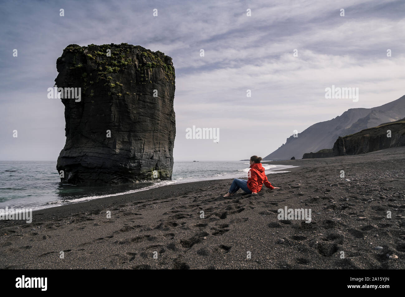 Woman on lava beach in South East Iceland, looking at the sea Stock Photo