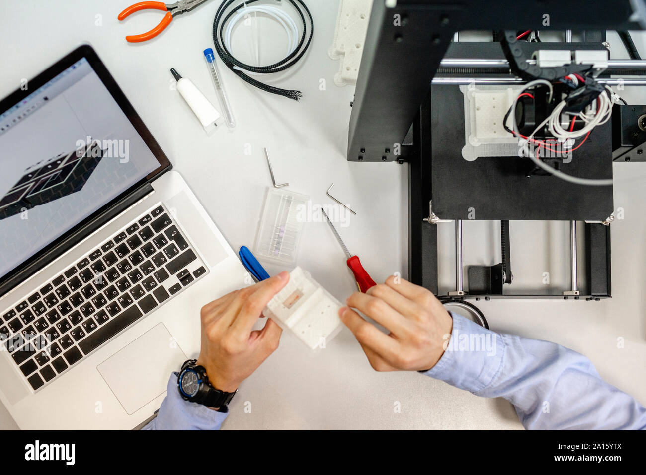 Student setting up 3D printer, overhead view Stock Photo
