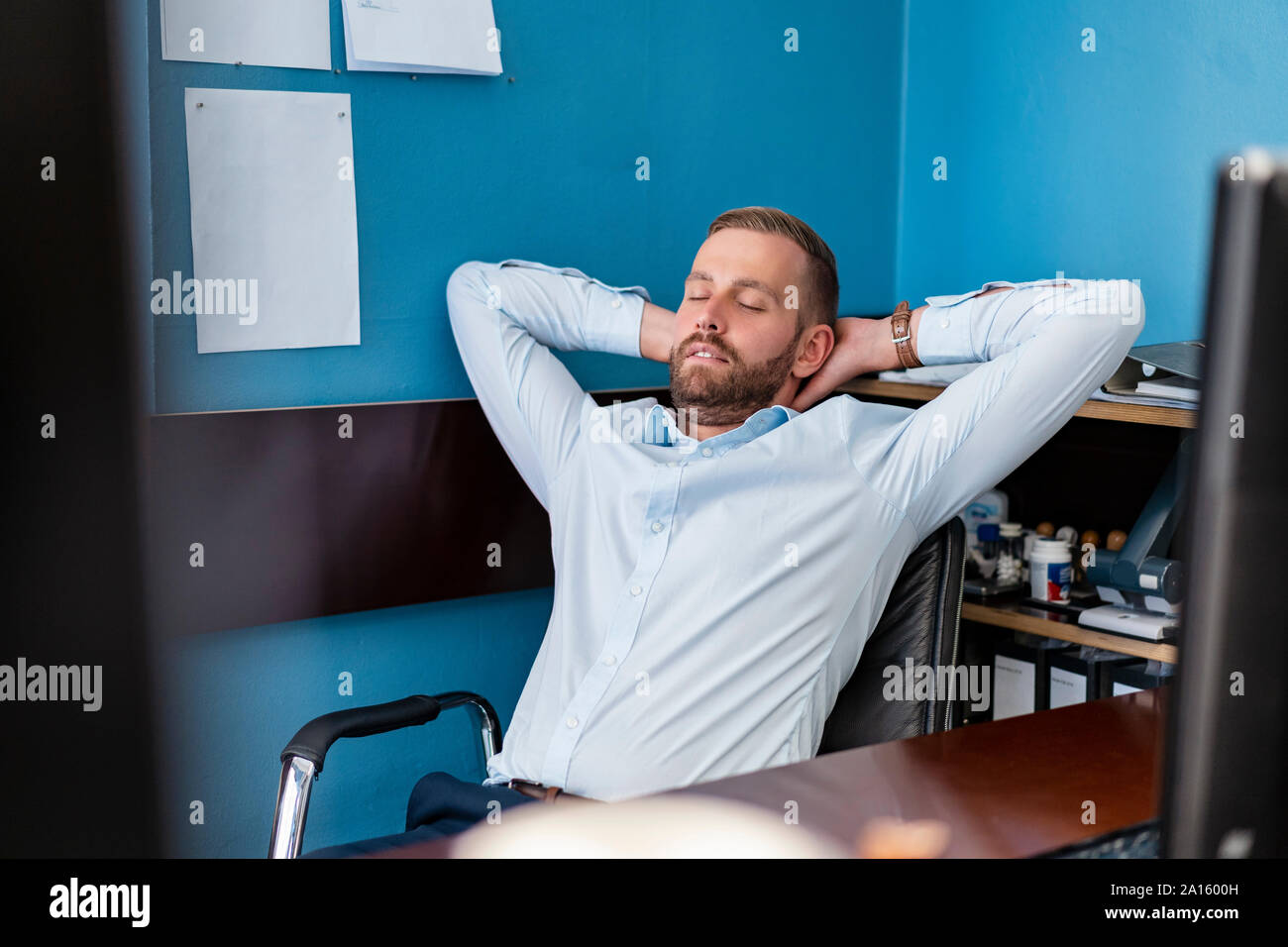 Tired businessman leaning back at desk in office Stock Photo Alamy