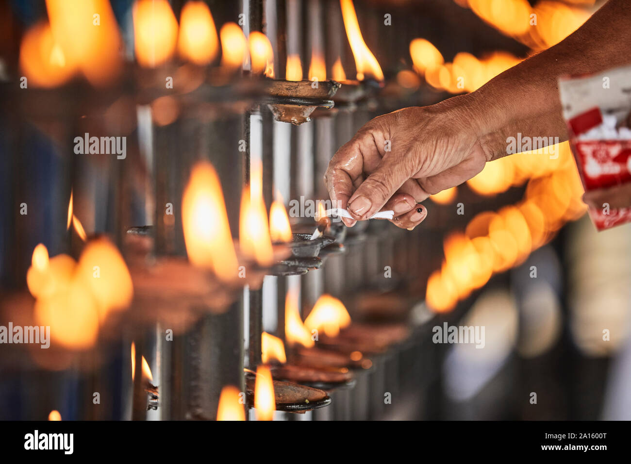 Hand lighting candle at Temple of the Sacred Tooth Relic, Kandy, Sri Lanka Stock Photo