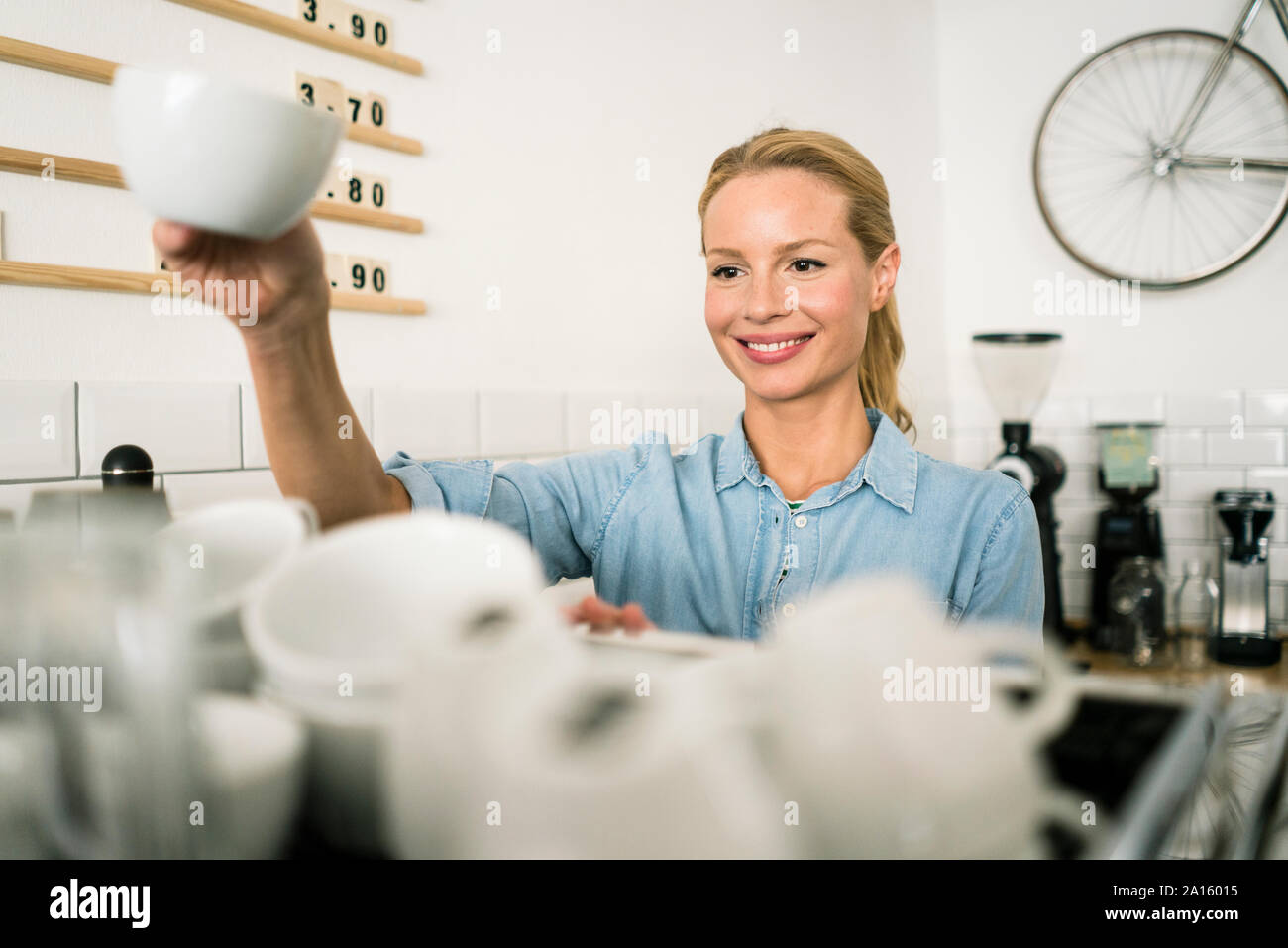 Blond woman working at the counter of a coffee shop Stock Photo