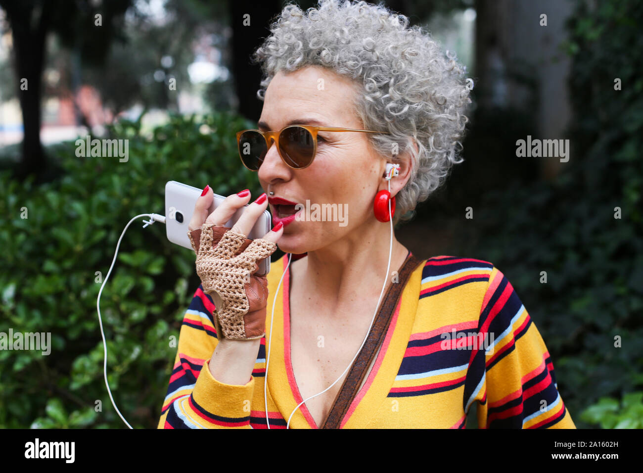 Portrait of pierced mature woman using smartphone outdoors Stock Photo