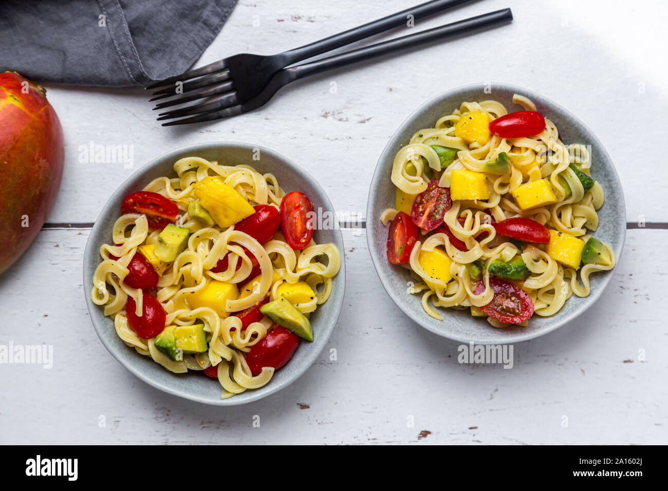 Two bowls of pasta salad with mango hires stock photography and images
