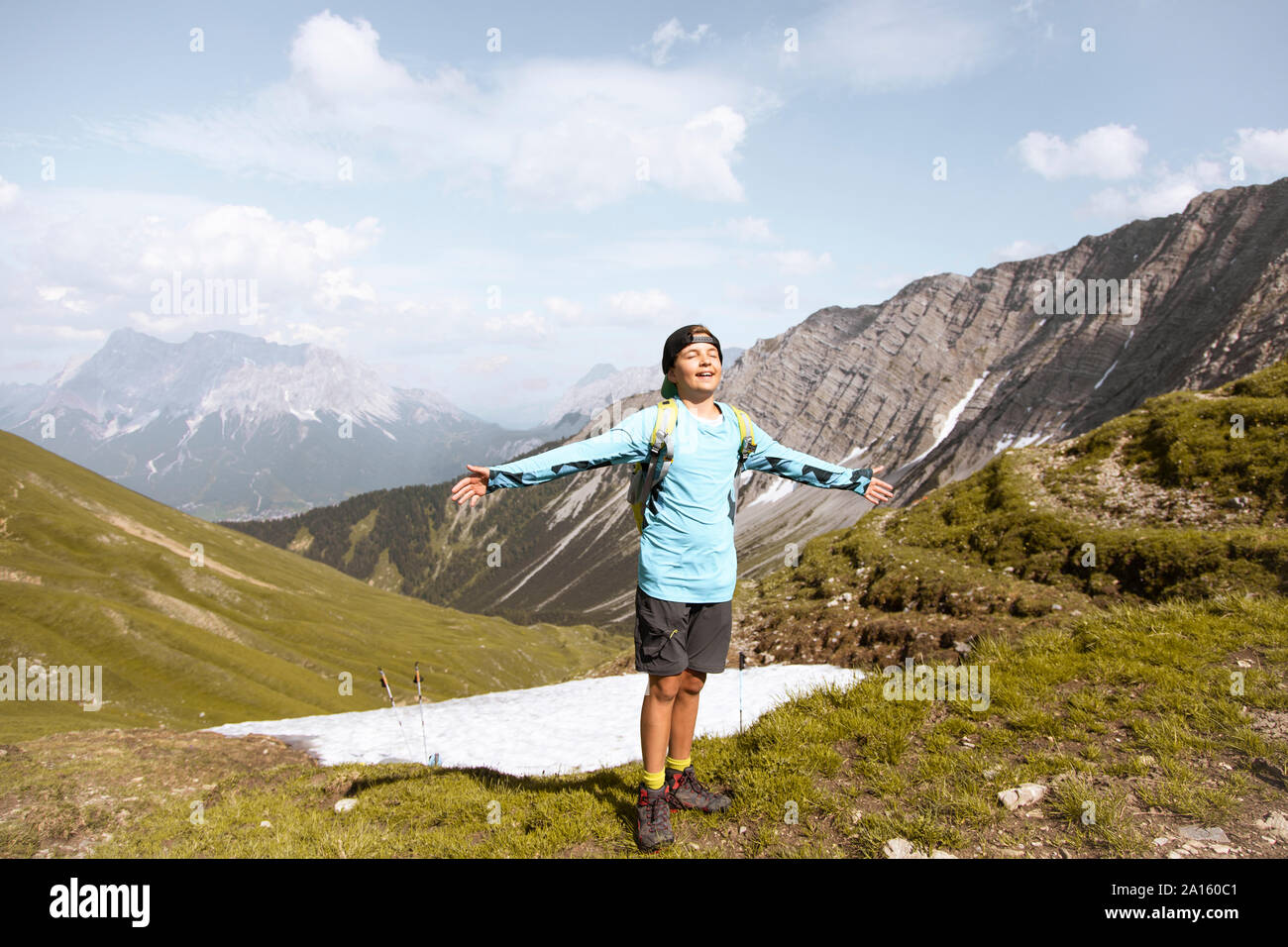 Boy hiking in the mountains enjoying nature Stock Photo