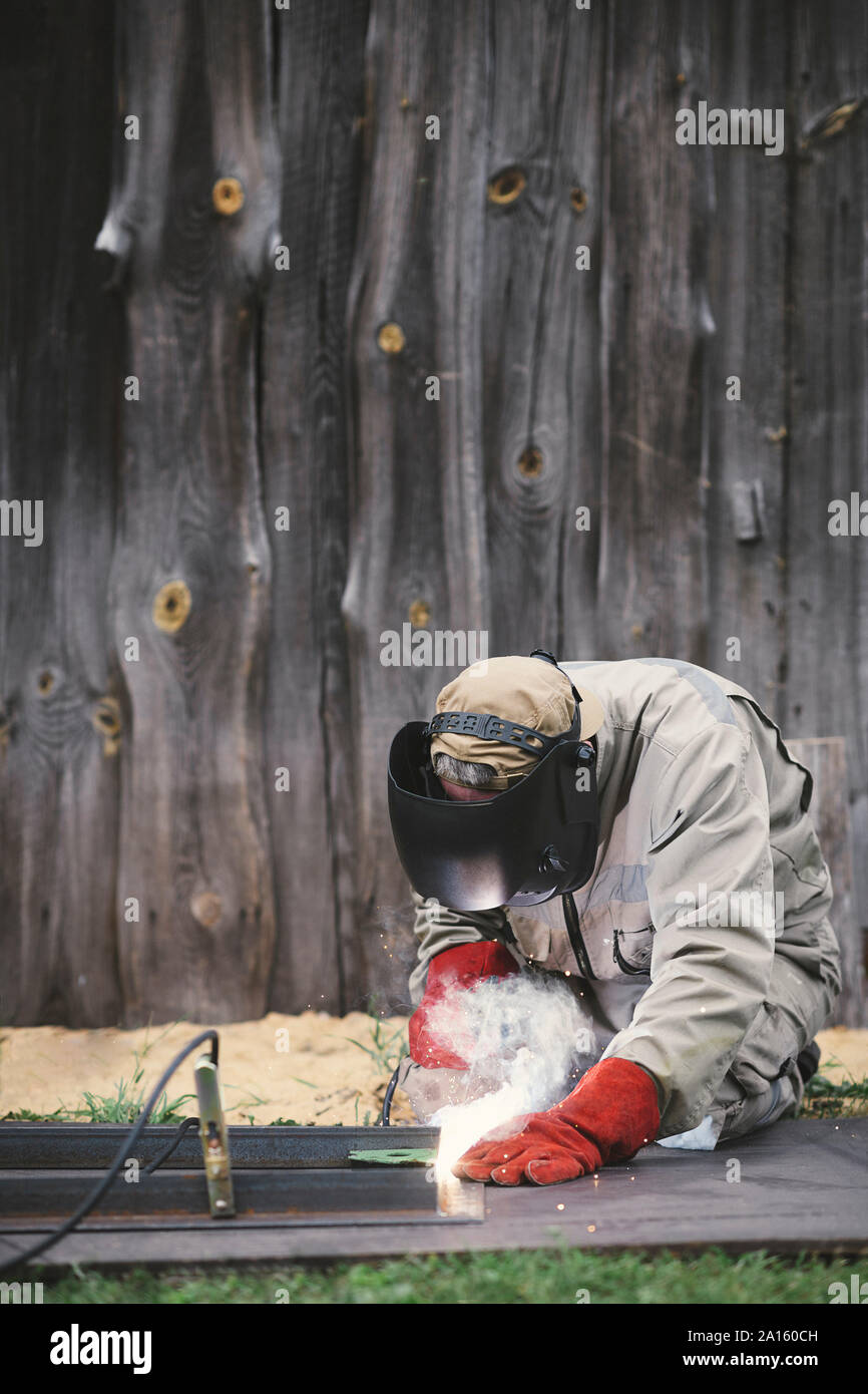 Man welding metal in his backyard Stock Photo