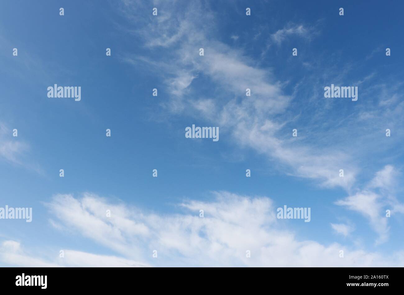 Wispy white cirrus clouds in blue sky Stock Photo