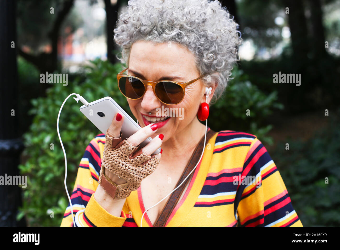 Portrait of pierced mature woman using smartphone outdoors Stock Photo