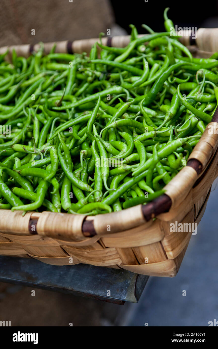 Green peppers in a wicker basket on a market stall Stock Photo - Alamy