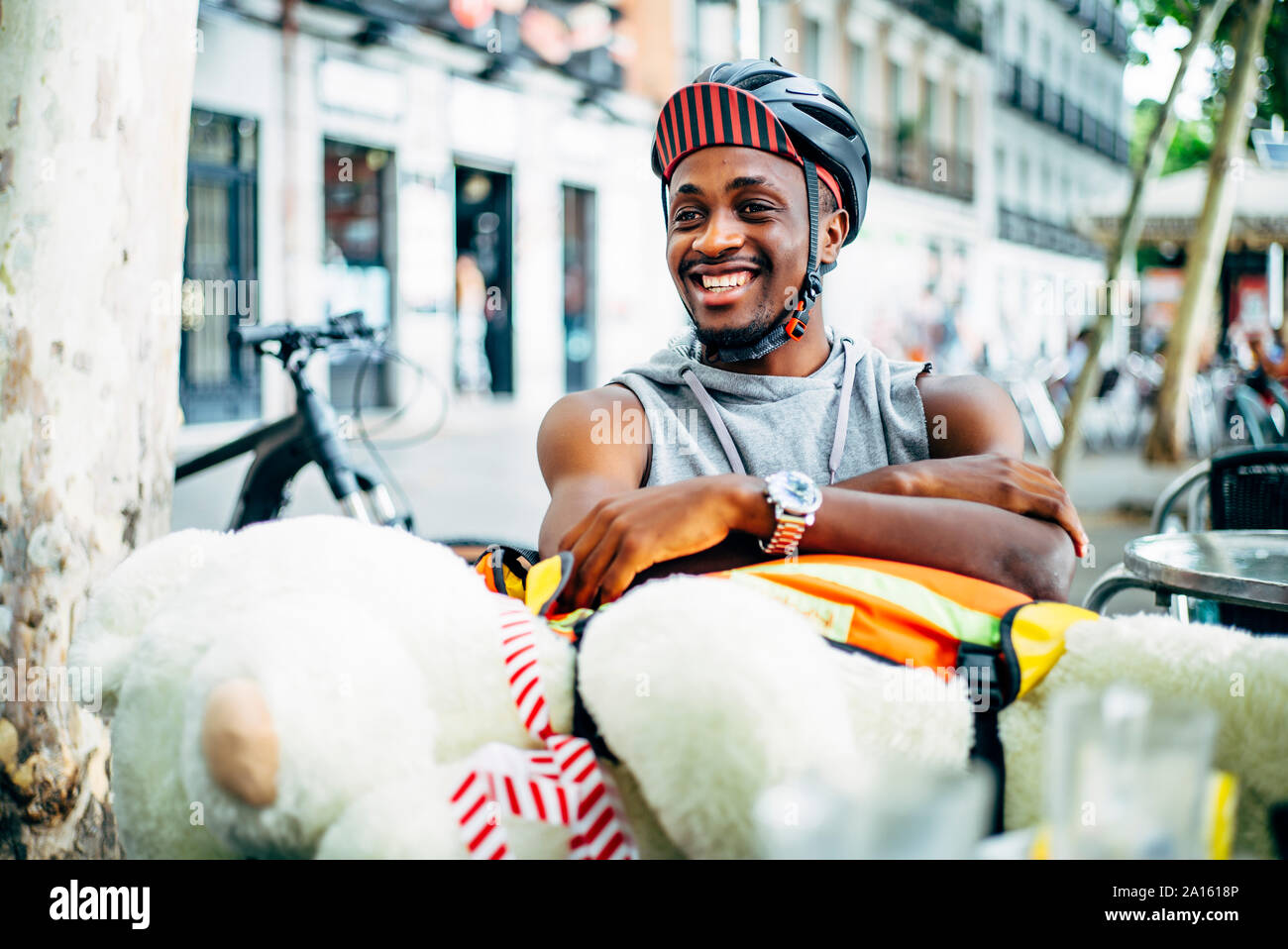Portrait of happy bicycle courier delivering a teddy bear Stock Photo