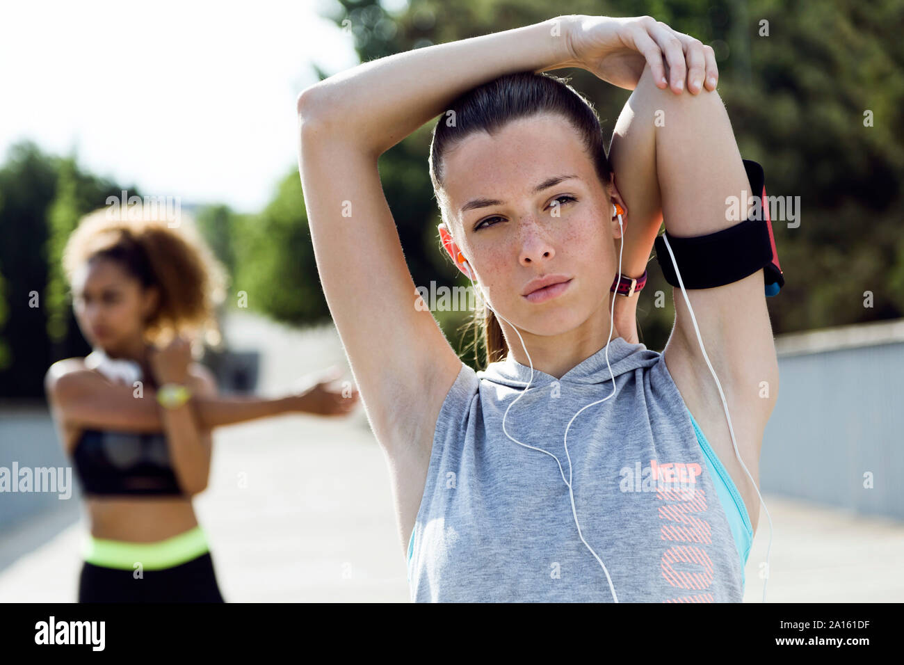 Two sporty young women doing stretching exercise Stock Photo