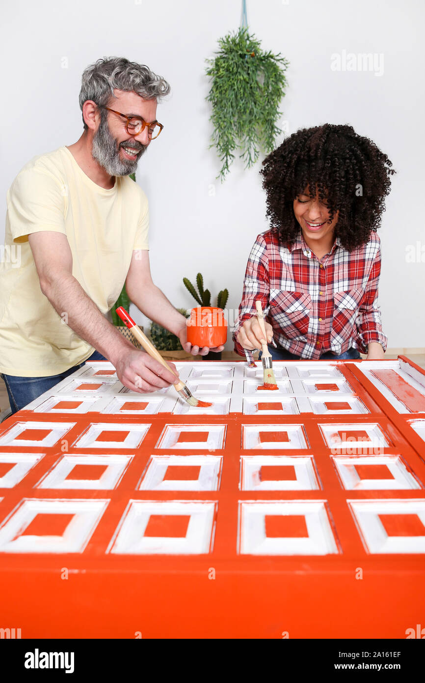 Couple painting furniture with brush at home Stock Photo