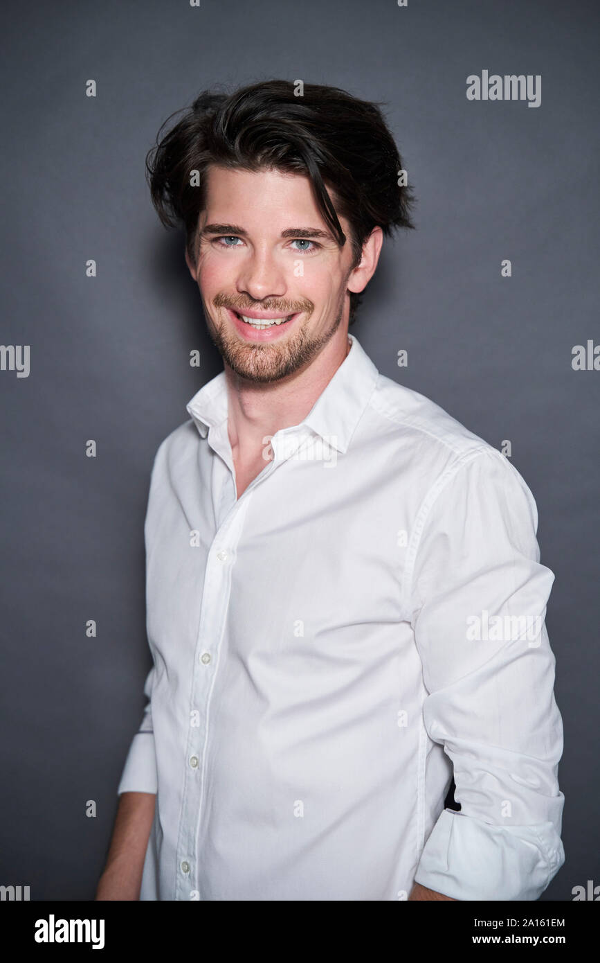 Portrait of smiling handsome man wearing white shirt Stock Photo