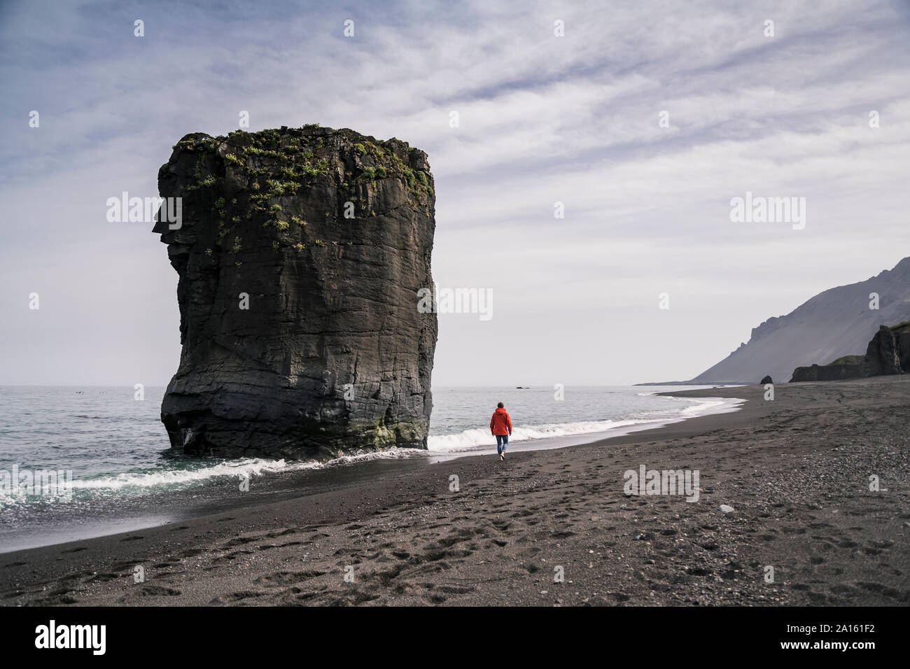 Woman on lava beach in South East Iceland, walkng at the sea Stock Photo