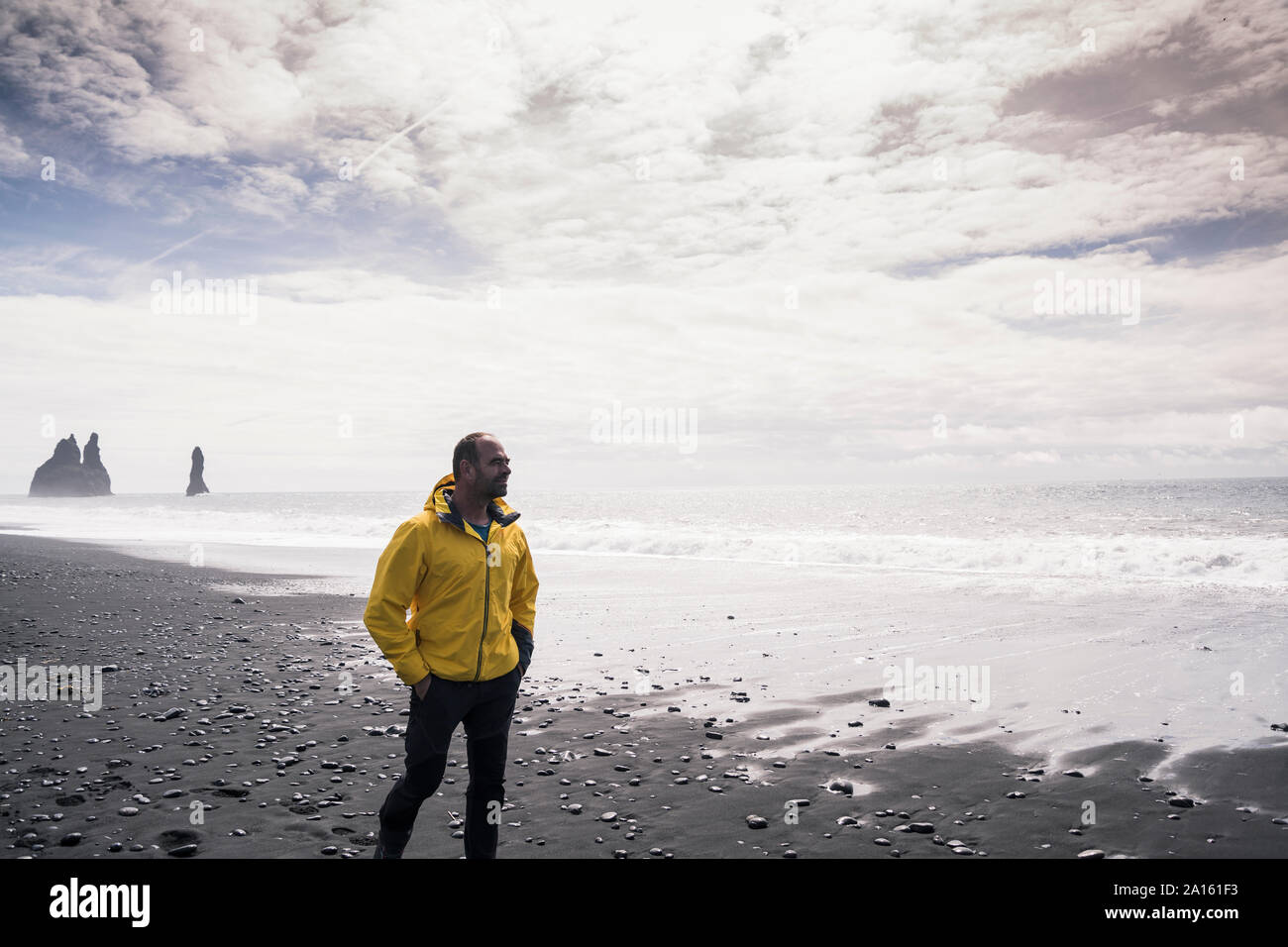 Mature man walking on a lava beach in Iceland Stock Photo