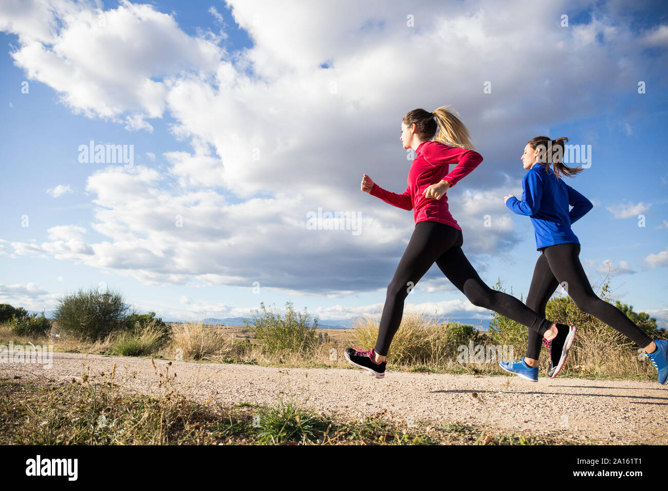 Young women running together in countryside Stock Photo