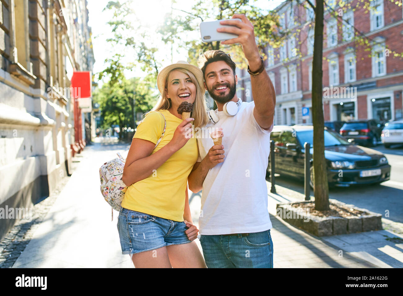 Happy young couple taking a selfie while eating ice cream in the city Stock Photo