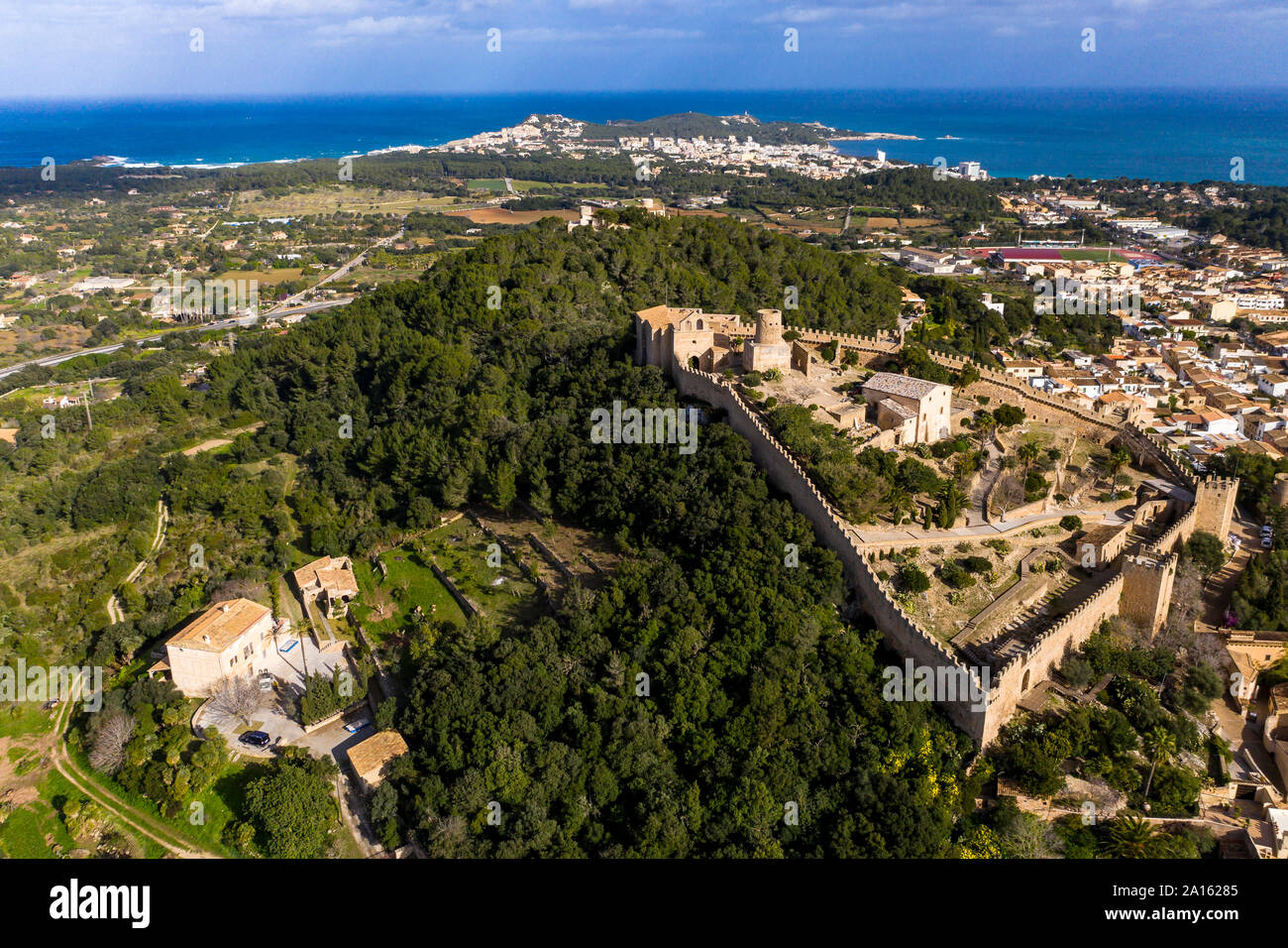 Aerial view of Castle Of Capdepera in village by Mediterranean Sea against sky Stock Photo