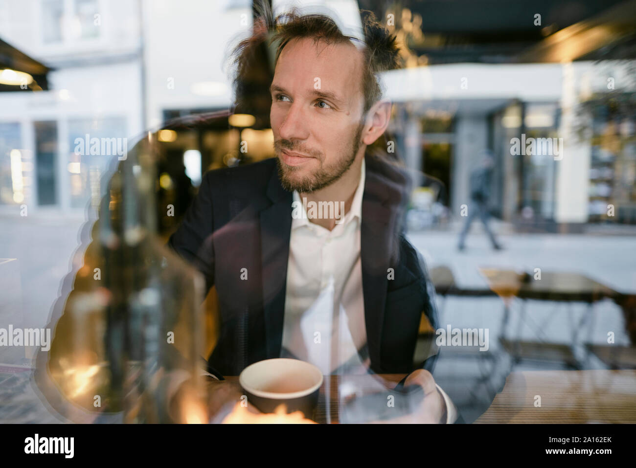 Portrait of businessman in a cafe looking out of window Stock Photo