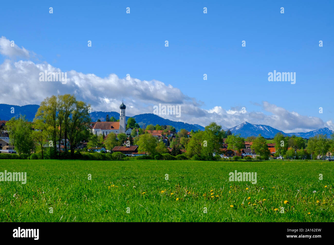 Grass and trees in front of town in Alpine Foothills, Konigsdorf, Bavaria, Germany Stock Photo