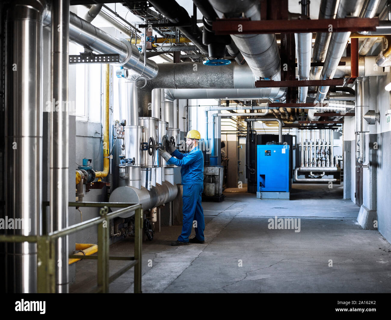 Technician turning a valve Stock Photo Alamy