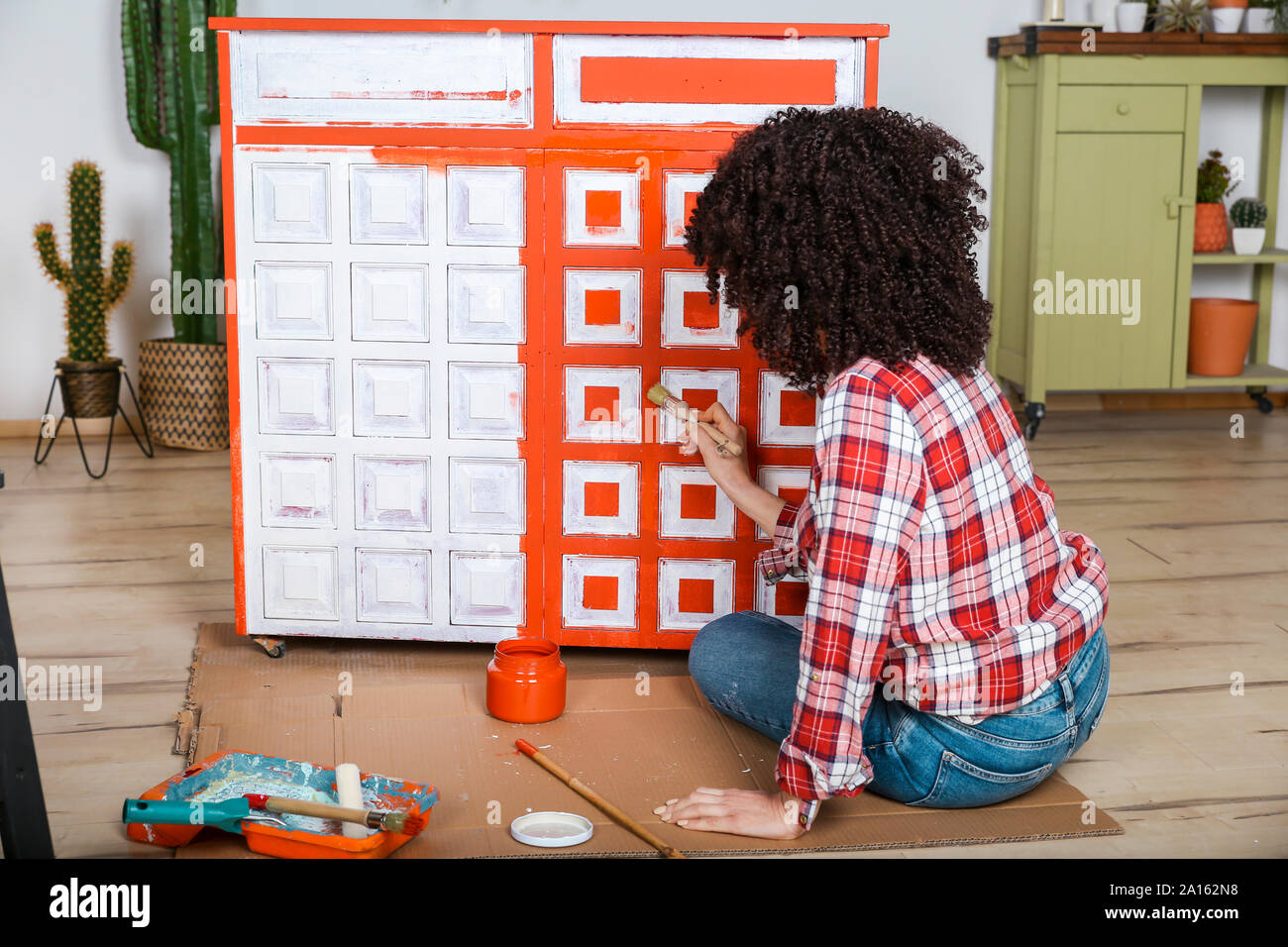 Rear view of woman painting furniture with brush at home Stock Photo