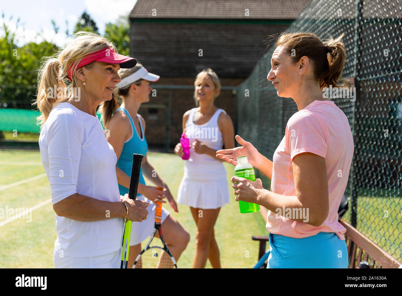 Mature women at tennis club taking a break from playing Stock Photo