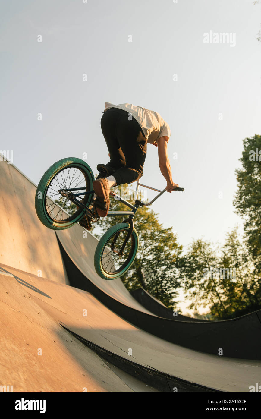 Young man riding BMX bike at skatepark Stock Photo