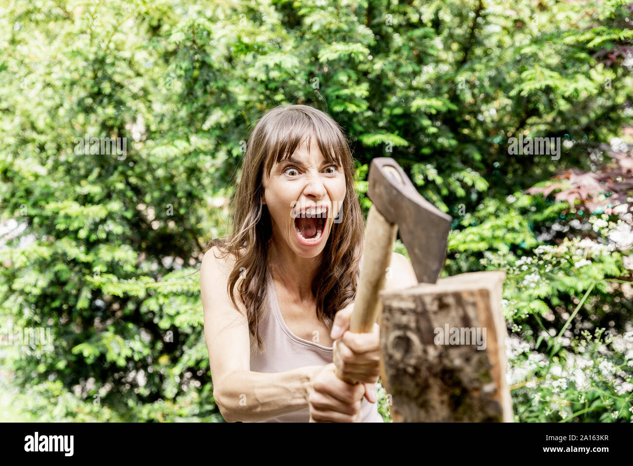 Screaming woman chopping wood Stock Photo