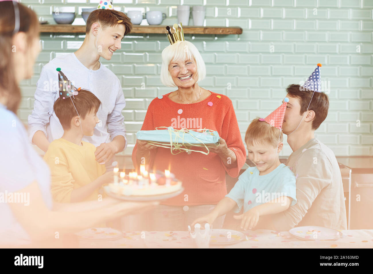 Mother and sons celebrating grandmother's bithday in their kitchen Stock Photo