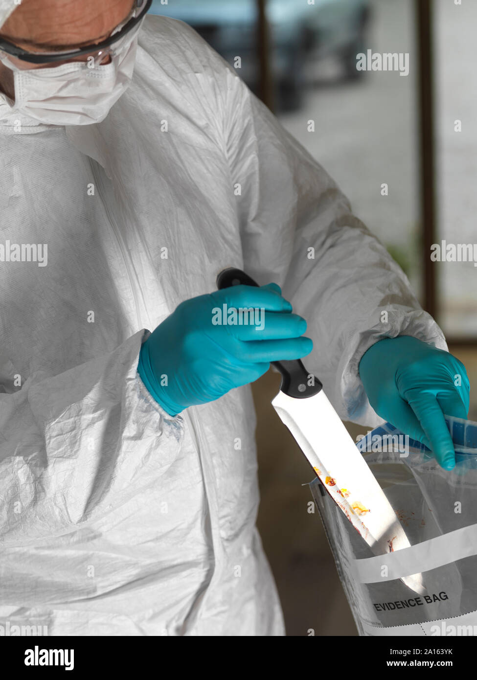 Forensic scientist bagging a knife taken from a violent crime scene Stock Photo