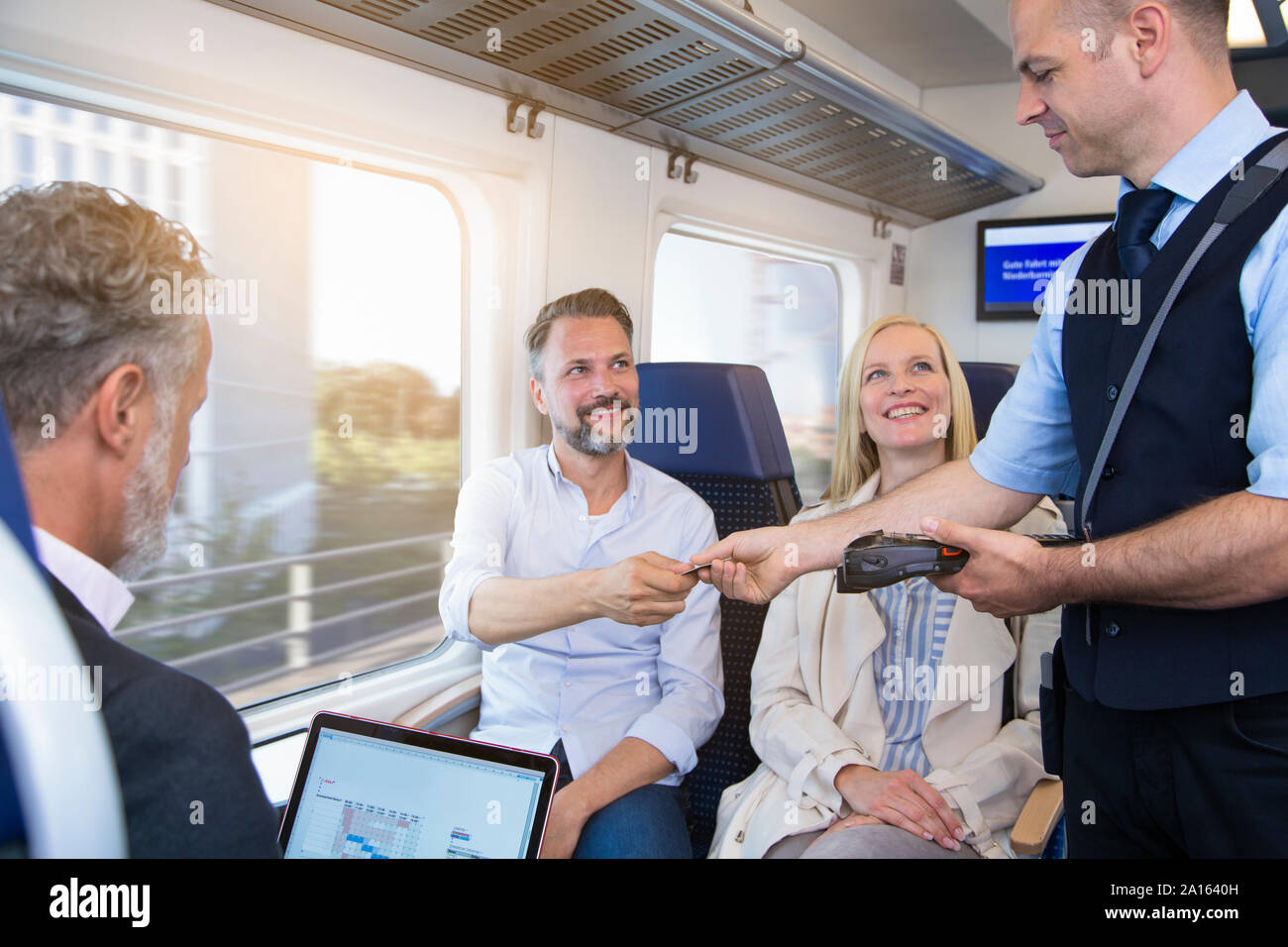Conductor checking tickets of passengers in a train Stock Photo Alamy