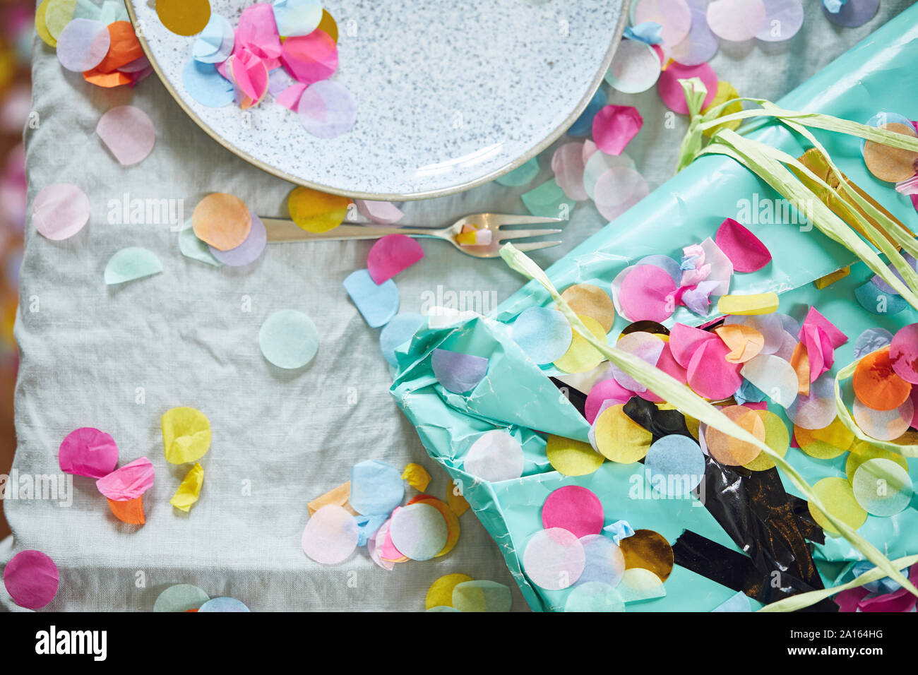 Present on table, decorated with confetti Stock Photo