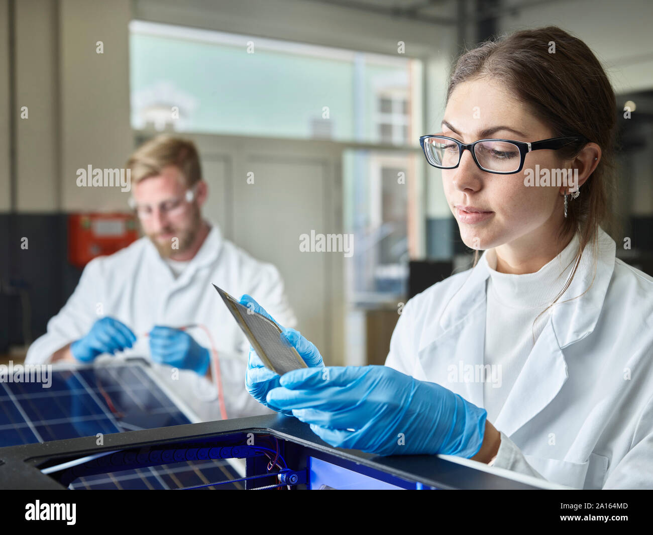 Two technicians working on solar cell in lab Stock Photo