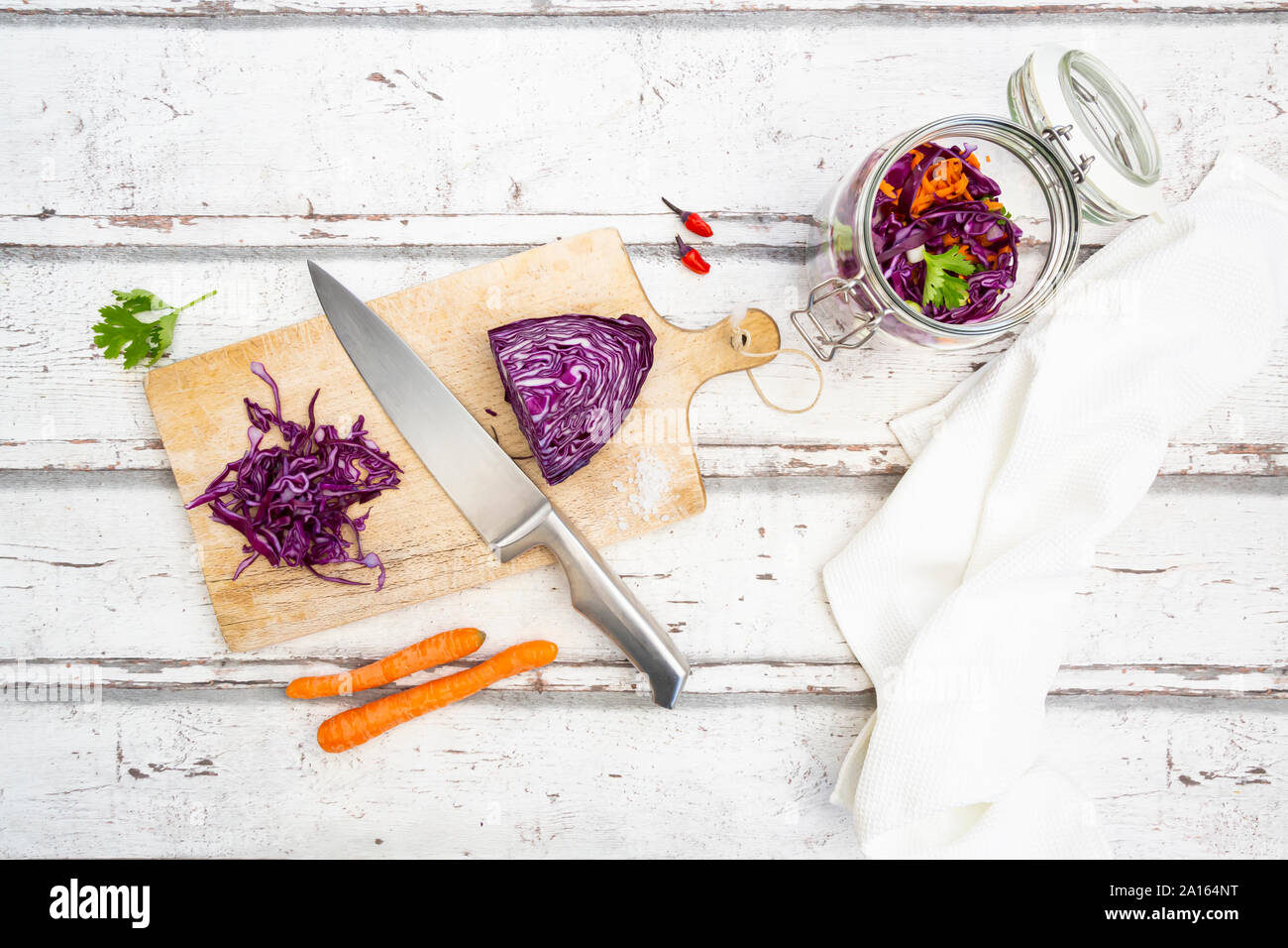 Red cabbage, chili peppers, carrots and coriander on wooden table Stock Photo