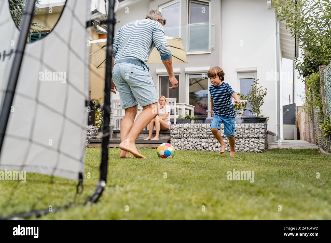 Father and son playing football in garden Stock Photo - Alamy