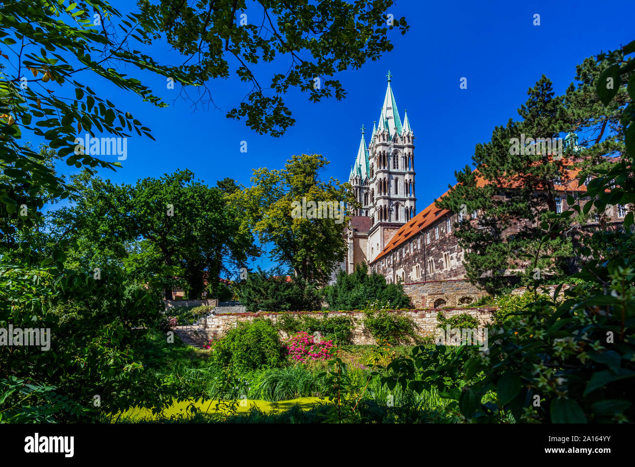 Low angle view of Naumburger Dom and trees against clear blue sky on sunny day Stock Photo