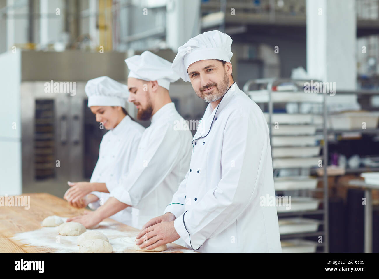 Baker with dough in hand in the bakery Stock Photo Alamy